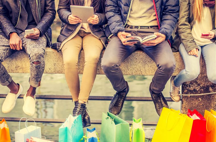 People sitting in a row with shopping bags