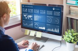 Image of man looking at metrics on computer screen