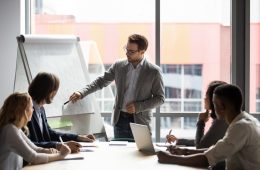 Businessman showing colleagues something on whiteboard